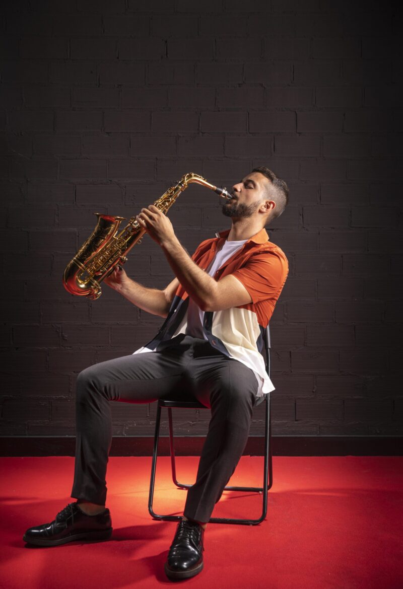 Man playing the saxophone while sitting