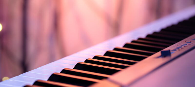 Music keys under colored lighting on a blurred background.
